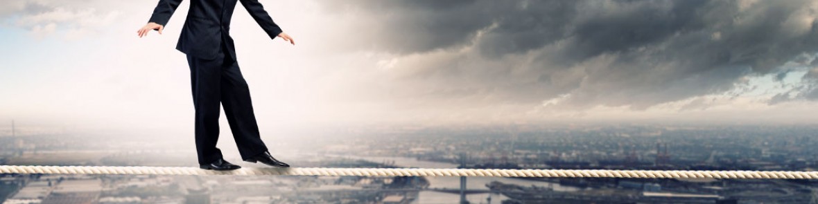 Person doing balance on edge of tall building