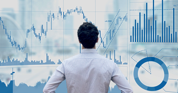 Man standing in front of financial data dashboard
